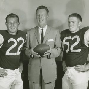 Coach Jim McConlogue with Charley Bartos (HB) and Bob Howard (C), 1960